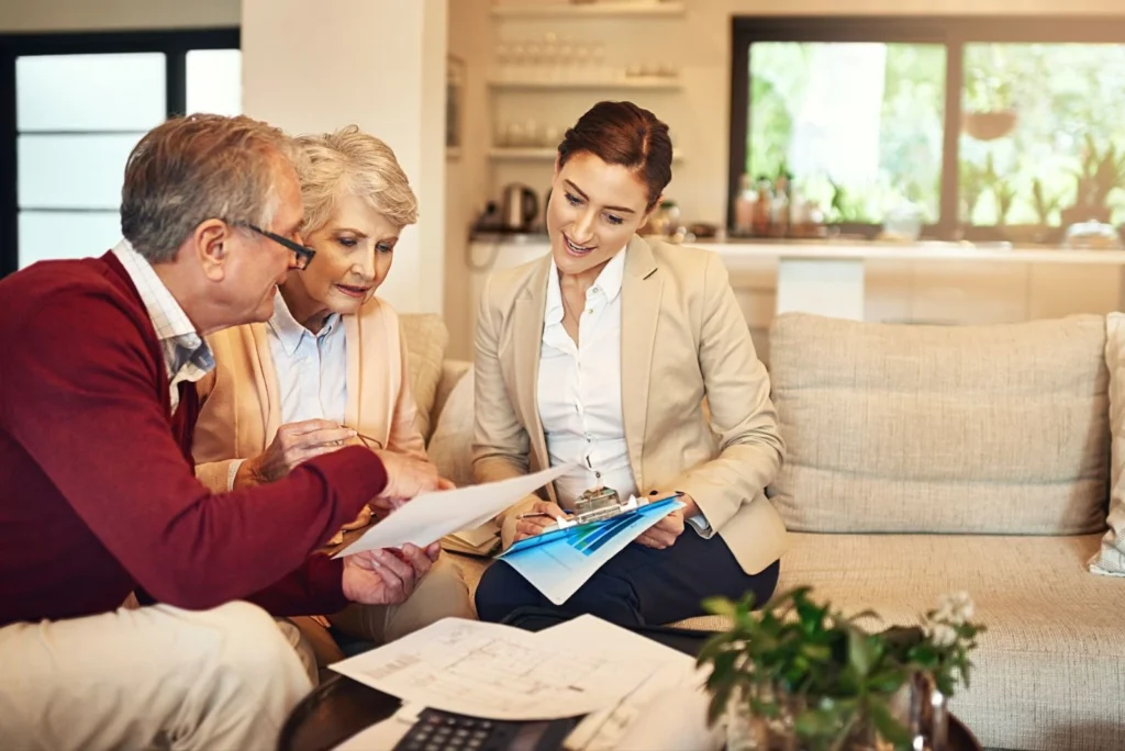 A real state female agent checking legal documents with elder people inside their new homes.