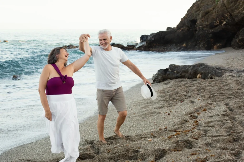 Elder people dancing and enjoying the beach.