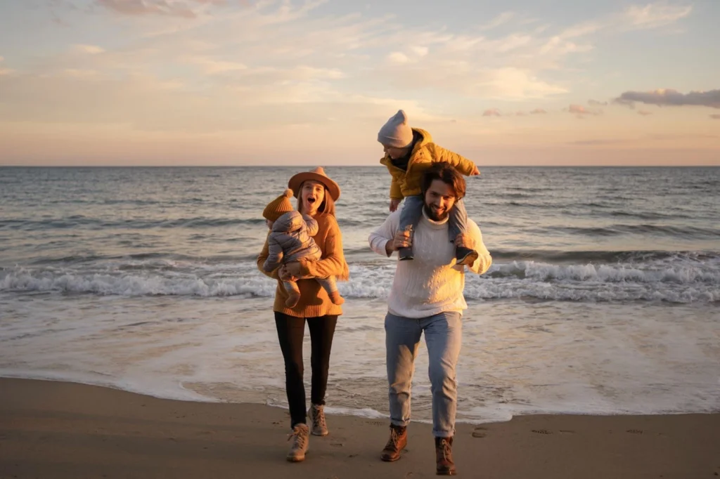 Family enjoying the beach as it sunsets through them.