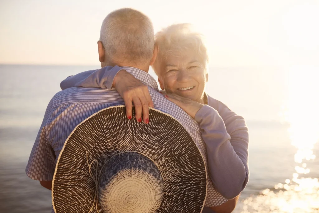 A couple of elder people holding each other while the each stand behind them.