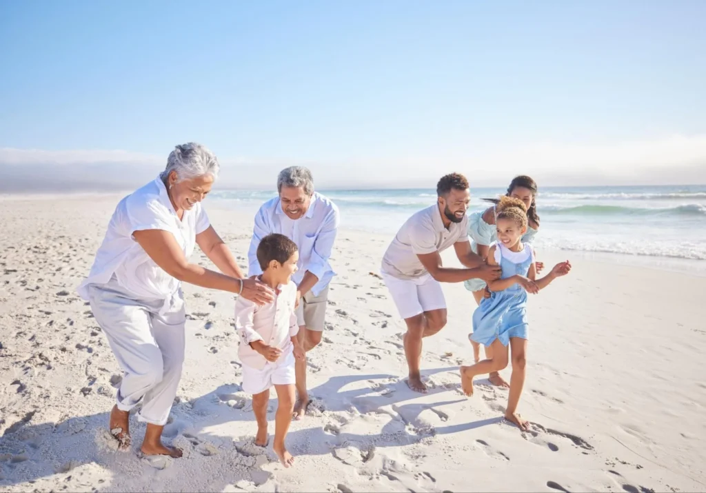 Family running through a Mexican beach, wether it's Los Cabos vs Tulum-