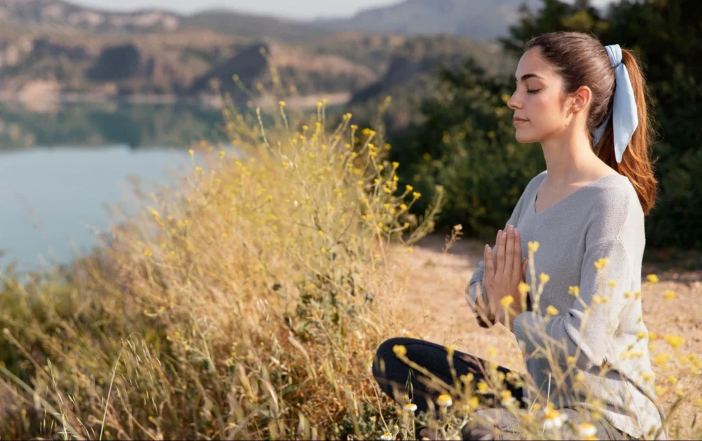 Woman meditating in quiet spaces for mental health.