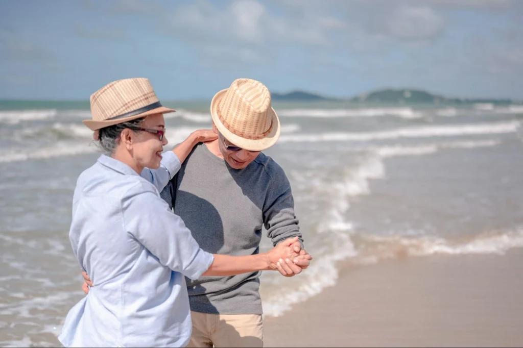 Couple dancing and enjoying life in front of the beach.